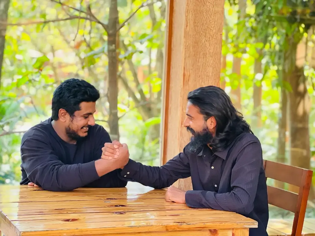 Two colleagues arm-wrestling across a table on a team day